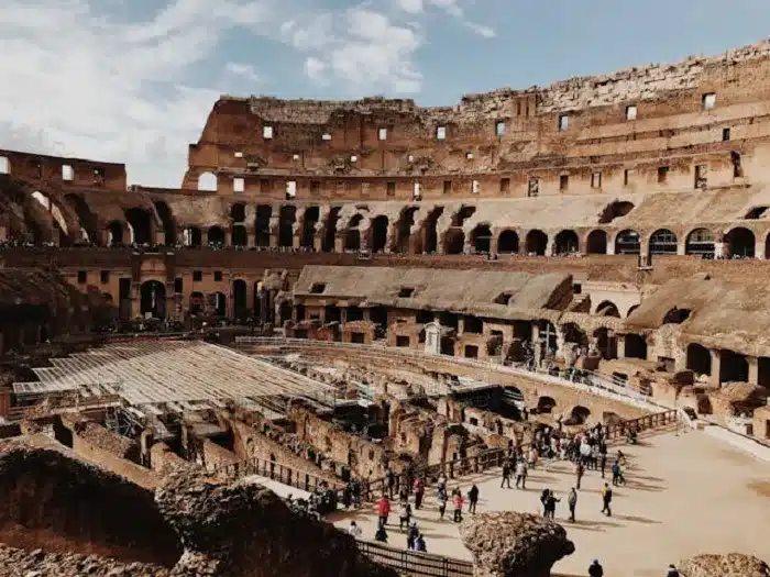 A group of people standing inside of Colosseum in Rome