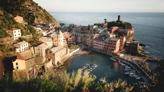 a bunch of house and boats on the edge of a mountain in Cinque Terre which is one of the best places to visit in Italy