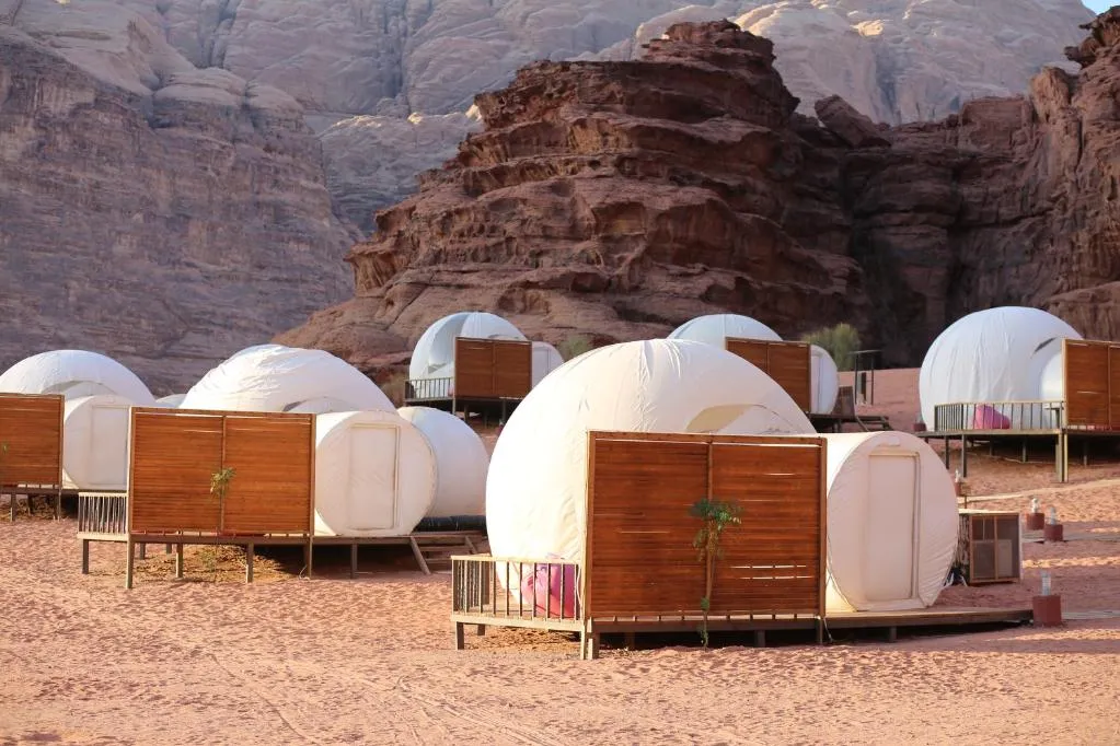 Tents are established in the desert, surrounded by sand dunes, illustrating a tranquil and remote outdoor setting in our Jordan itinerary 5 days