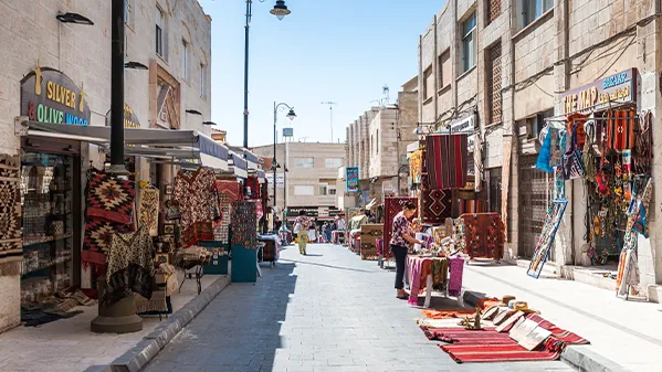 1. A bustling street filled with numerous pedestrians engaged in various activities as they walk along the pathway in our Jordan itinerary 5 days